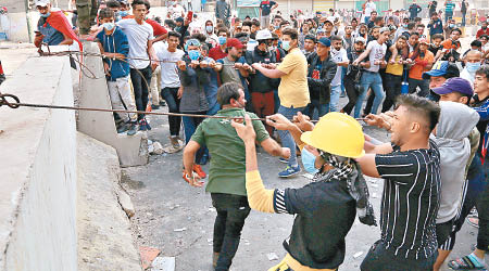 示威者試圖拉倒阻隔安全部隊的水泥路障。（美聯社圖片）