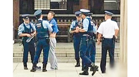 胡大平（左三）早前於靖國神社被警員制服。（互聯網圖片）