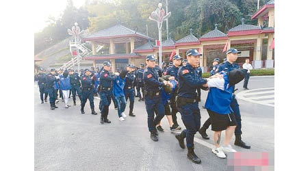 中國警方在越南執法人員手上接收疑犯，押解回國受審。