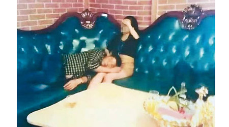 林男（左）躺在陪酒女的大腿上睡覺。