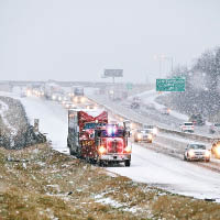 拖車拖走風雪中的死車。（美聯社圖片）