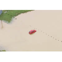 一輛汽車被洪水圍困。（美聯社圖片）
