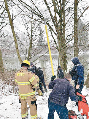 救援人員在消防員協助下爬上樹。