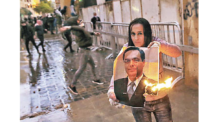 示威者焚燒總理迪亞卜的肖像。（美聯社圖片）