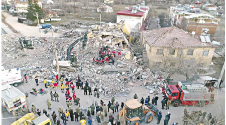 地震破壞力驚人，救護人員在瓦礫中搜救生還者。（美聯社圖片）