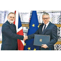 英國駐歐盟大使巴羅（左）向歐盟理事會秘書長葉普（右）提交文件。（美聯社圖片）