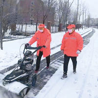 工作人員清理公路上積雪。