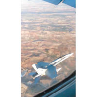 西班牙空軍派出F18戰機飛近客機，評估損毀情況。
