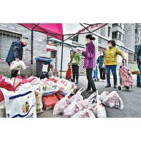 武漢市民眾領取食物時都戴口罩。（美聯社圖片）