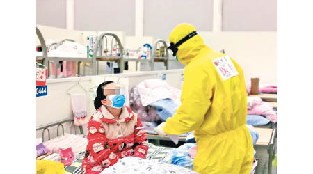 在湖北省武漢市漢陽方艙醫院，醫護人員詢問患者情況。（中新社圖片）
