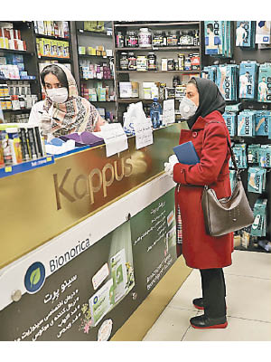 伊朗民眾在德黑蘭一間藥房買防疫物資。（美聯社圖片）