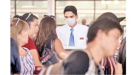 智利出現首宗確診病例，聖地亞哥機場的航空公司職員戴口罩。（美聯社圖片）