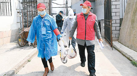 社區工作人員為武漢居民運送生活物資。（中新社圖片）