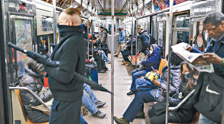 在紐約市地鐵車廂內，不少乘客戴口罩自保。（美聯社圖片）