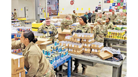 俄亥俄州國民警衞軍在克利夫蘭協助重新包裝緊急食物盒。（美聯社圖片）