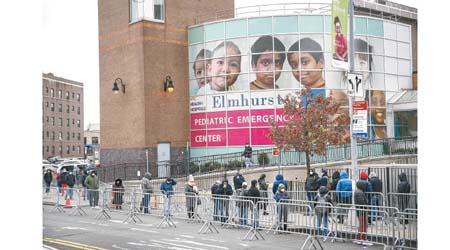在紐約州埃爾姆赫斯特，民眾排隊接受新冠病毒檢測。（美聯社圖片）