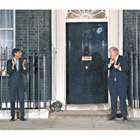 約翰遜（右）早前與財政大臣辛偉誠，在唐寧街首相府外，為醫護打氣。（美聯社圖片）