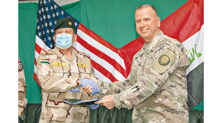 美軍代表（右）與伊拉克政府軍代表（左）簽署文件。