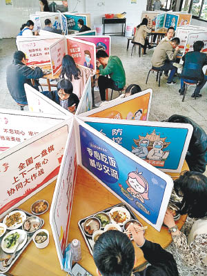 福建省有鎮政府食堂的餐桌以圍板分隔，防止交叉感染。（中新社圖片）