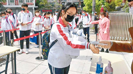 福建有學生進入校園前量度體溫。（中新社圖片）