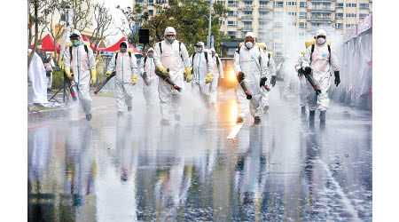 穿保護衣的台灣軍人在台北街頭進行防疫工作。（美聯社圖片）