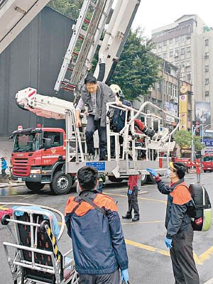 消防員用雲梯將被困者送回地面。