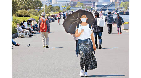 日本的新冠肺炎疫情反覆。東京民眾外出戴口罩。（美聯社圖片）