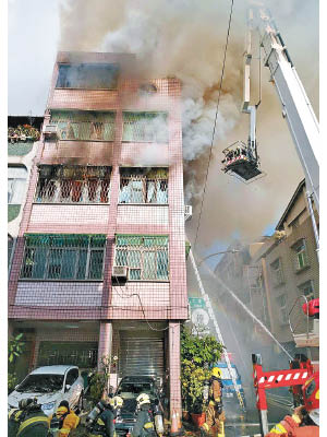 火場冒出濃煙，消防架起雲梯灌救。