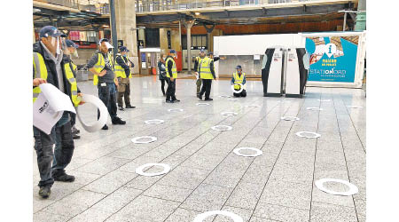 法國：巴黎北站職員在地板標示排隊要保持社交距離。（美聯社圖片）