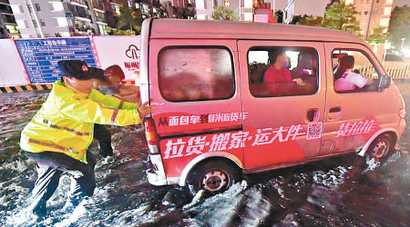 福州嚴重水浸，警員幫手推車。（中新社圖片）