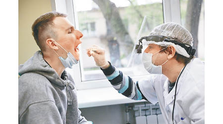 莫斯科醫護人員在軍方徵兵辦公室抽取樣本作病毒檢測。（美聯社圖片）