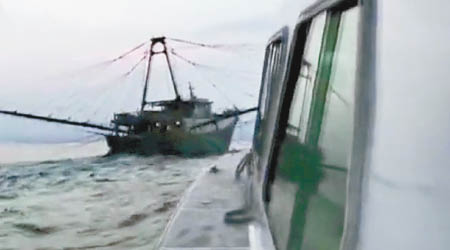 執法船駛近違規漁船（左）調查。
