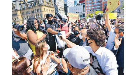 杜魯多（右）與示威者交流。（美聯社圖片）