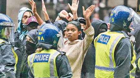 英國:倫敦示威者向警員舉起雙手。（美聯社圖片）