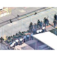 獄警進入運動場制服多名囚犯。（電視畫面）