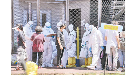 防疫人員在新發地批發市場附近，為居民上門檢查。（美聯社圖片）