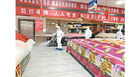 防疫人員在菜市場消毒。