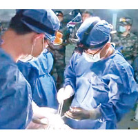 軍醫模擬在野戰醫院替傷兵施手術。
