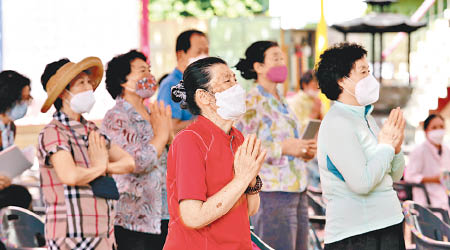 婦女們戴上口罩祈福。（美聯社圖片）