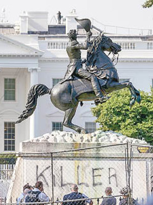 示威者在傑克遜雕像基座下塗鴉。（美聯社圖片）