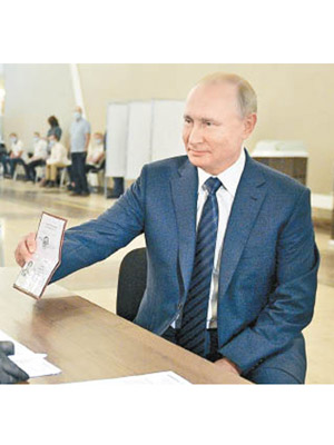 普京在票站登記資料時展示護照。（美聯社圖片）
