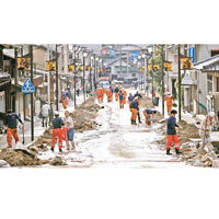 岐阜：消防及民眾收拾水浸過後的街道。