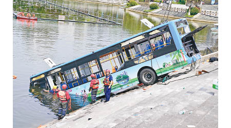 救援人員打撈起墮水庫的巴士。（中新社圖片）