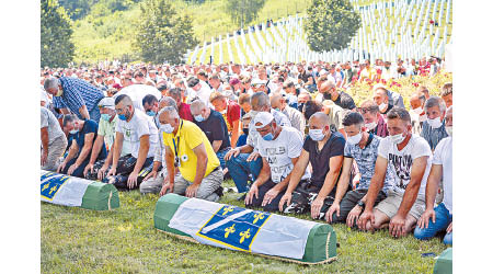 波斯尼亞民眾向死難者祈禱。（美聯社圖片）