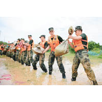 大批武警到鄱陽縣運沙包防洪。（美聯社圖片）