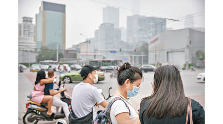 北京市民戴口罩外出。