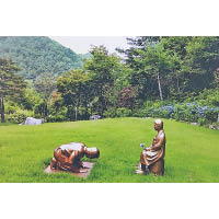南韓設置慰安婦雕像，旁有依安倍晉三所製的下跪雕像。（美聯社圖片）