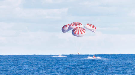 龍飛船打開降落傘，以海面濺落方式降落墨西哥灣。（美聯社圖片）