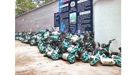 大批共享電單車被堆放在巷道內。