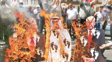 示威者焚燒內哈延及內塔尼亞胡的肖像。（美聯社圖片）